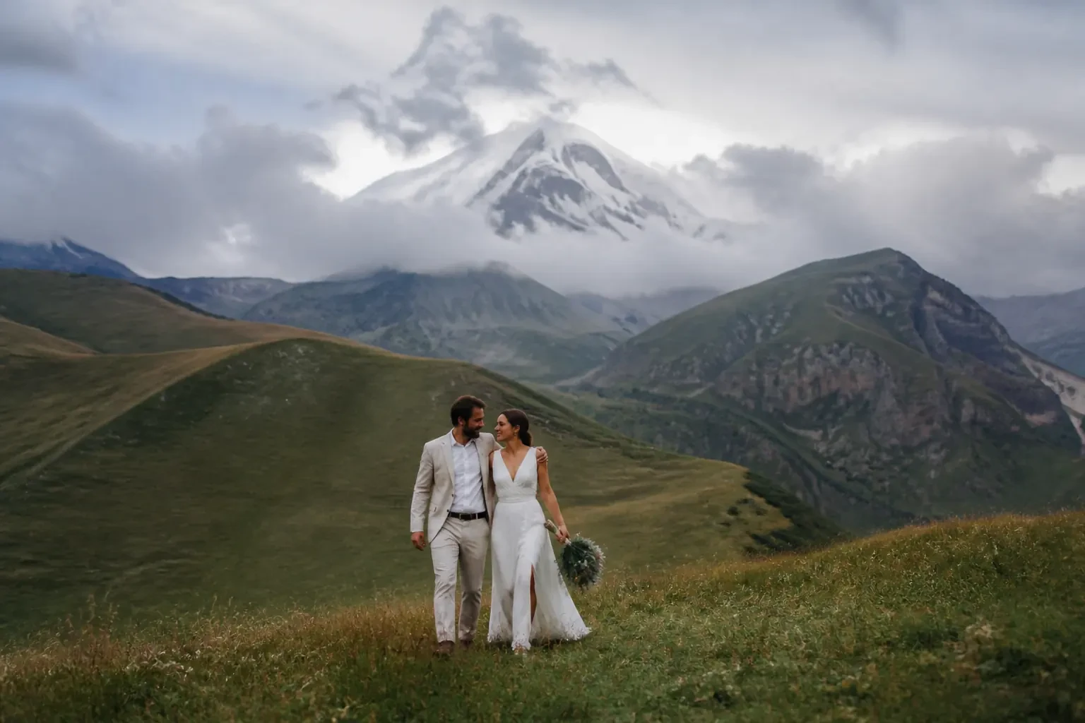 Камерная свадебная фотосессия пары в горах Кавказа у подножия вершины Казбек